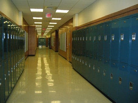 Image shows a school hallway with two rows of small gray-blue lockers.