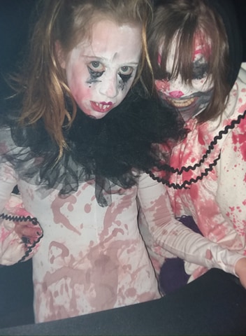 Two clowns, covered in smudgy makeup and fake blood.