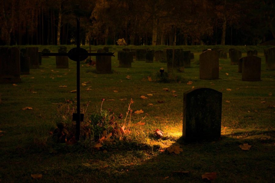 Picture of a graveyard with a light coming from the one in the center of the picture.