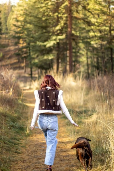 A person walking through the woods with their dog