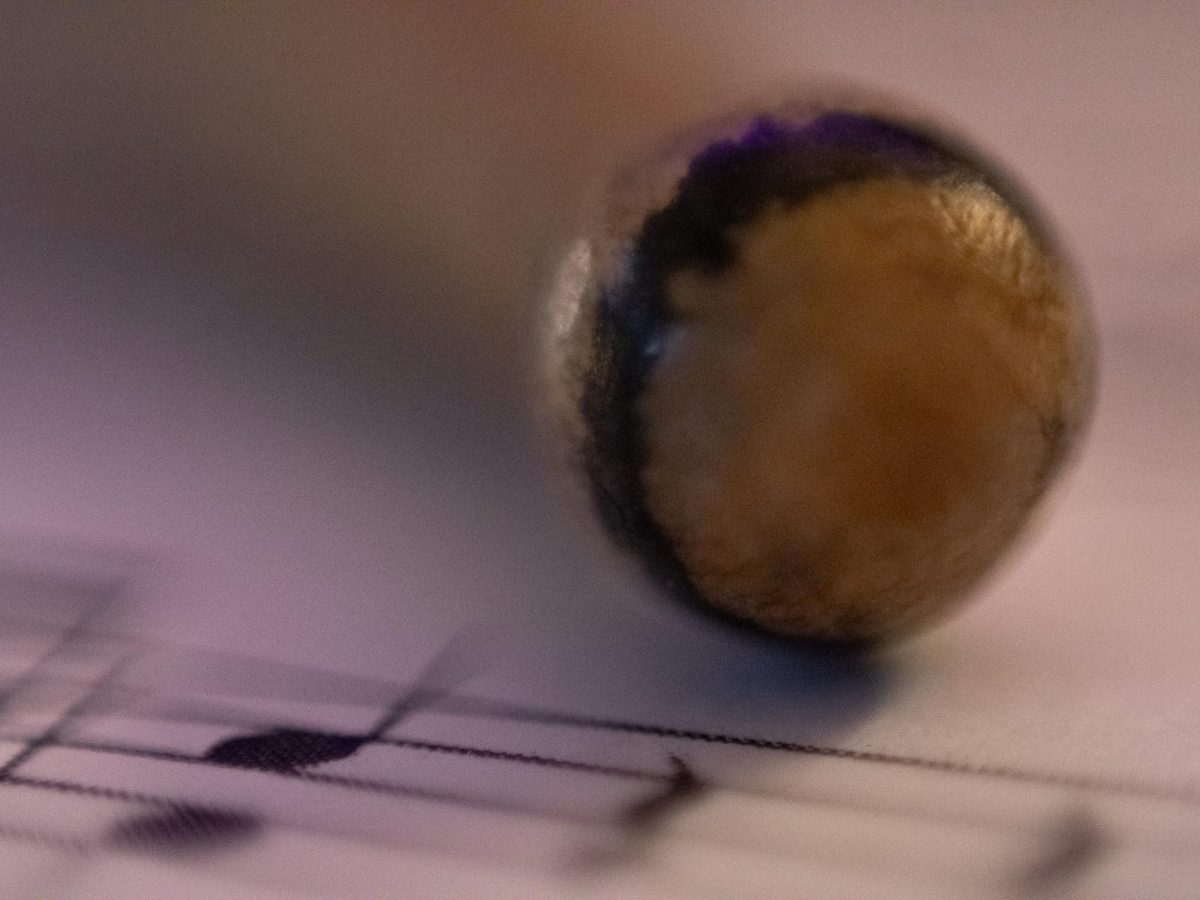 A drumstick next to the music it plays.